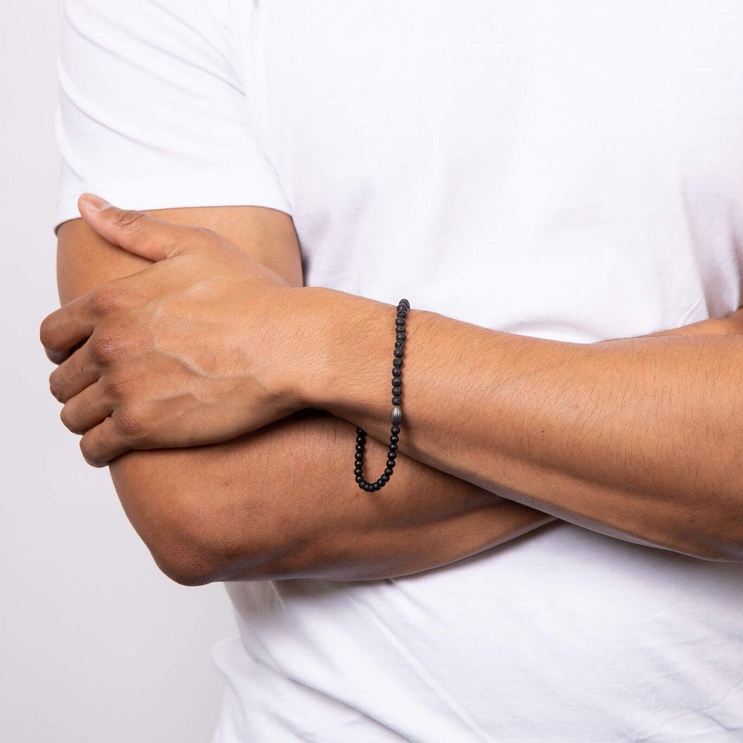 Fred Bennett men's beaded bracelet in black worn on wrist with white short sleeve shirt