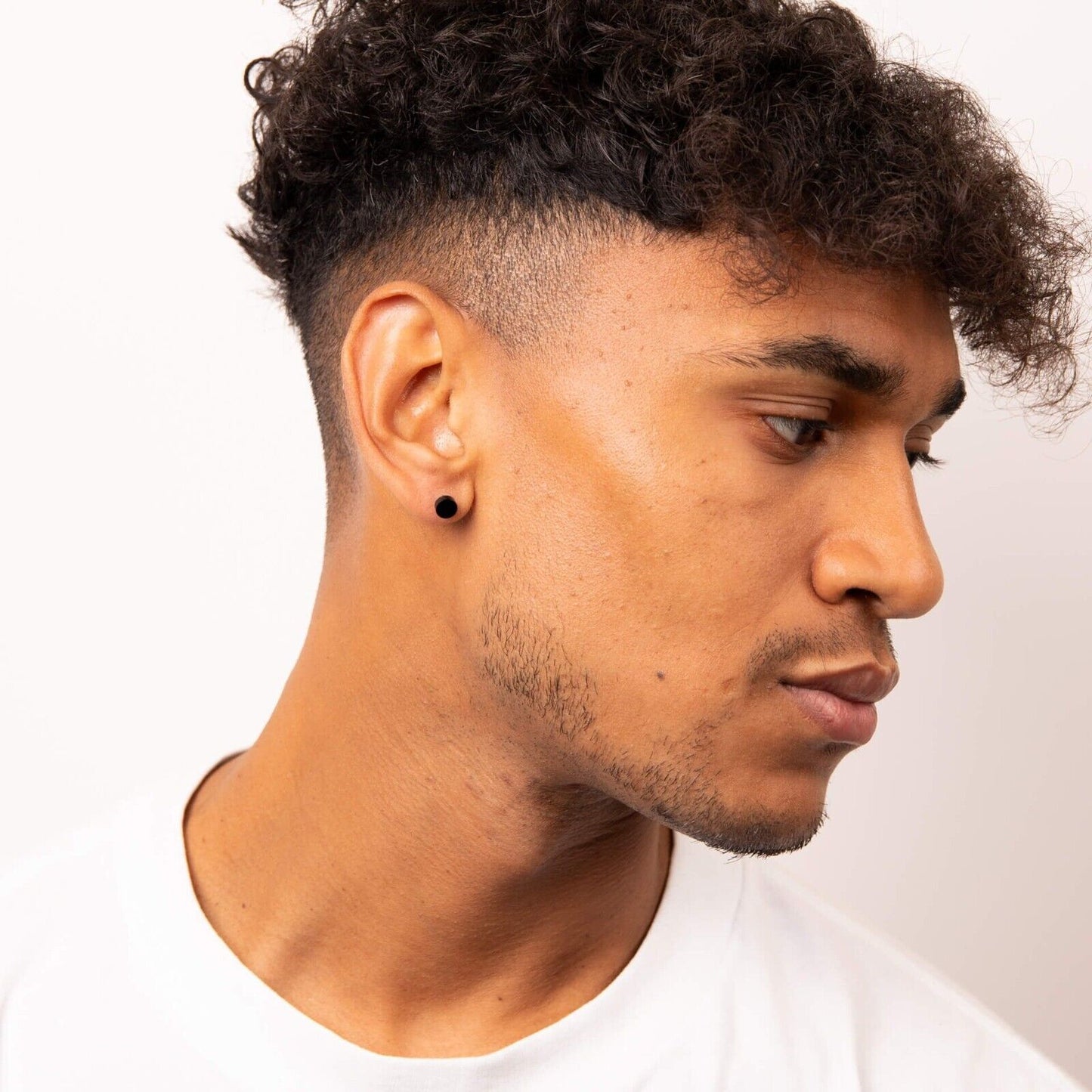 Close-up of a man wearing black stud earring showcasing modern men's jewellery UK by Fred Bennett