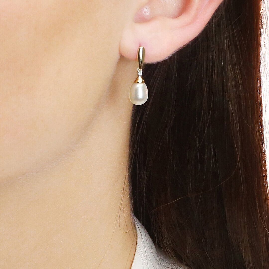 Freshwater pearl and diamond pendant set earring worn on ear with gold setting by J R Jewellery