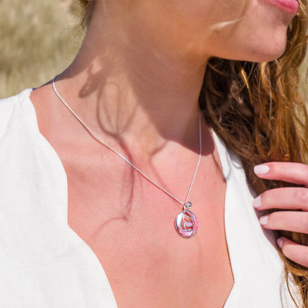 Mackintosh pink rose pendant on silver chain worn by woman in white top by J R Jewellery