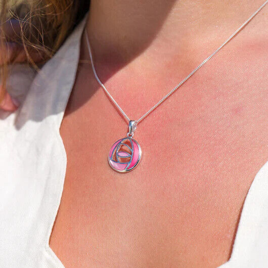 Mackintosh pink rose pendant necklace in silver worn on a woman’s neck against a white top