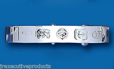 J R Jewellery sterling silver baby bangle with hallmark stamps on a blue background