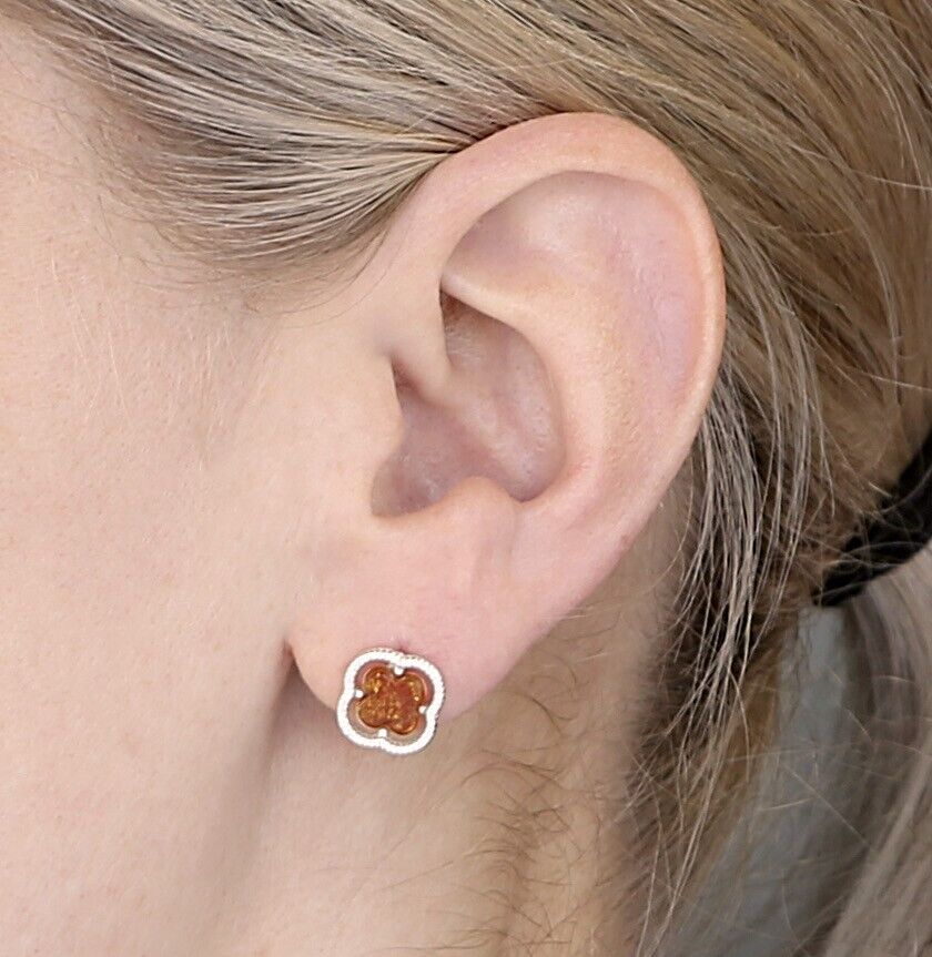Sterling silver clover earrings with amber stone detail worn on ear by model