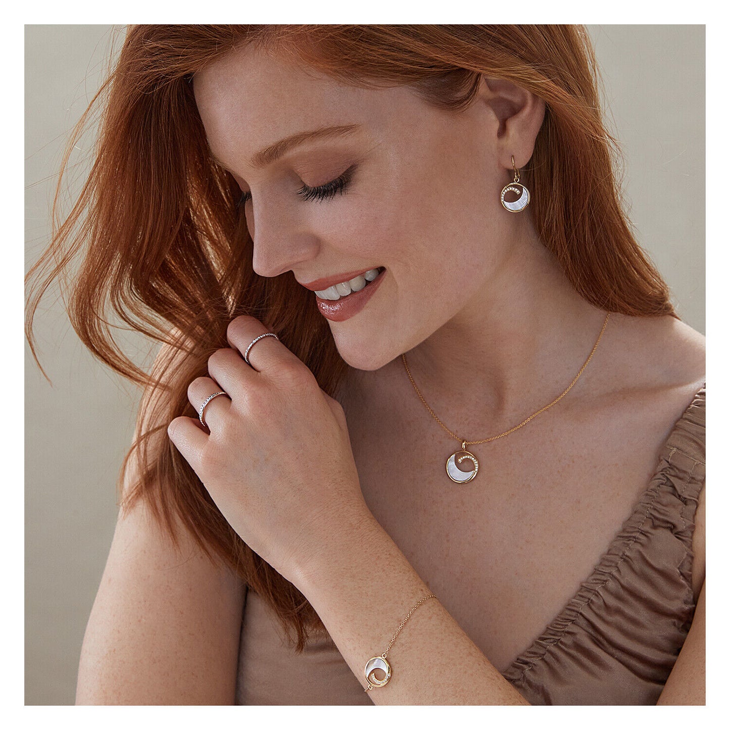 Woman wearing sterling silver half eternity ring with matching jewellery set and beige top
