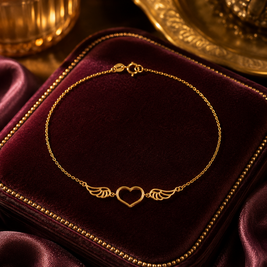 J R Jewellery Angel Wing Heart Bracelet in gold on a luxurious velvet display
