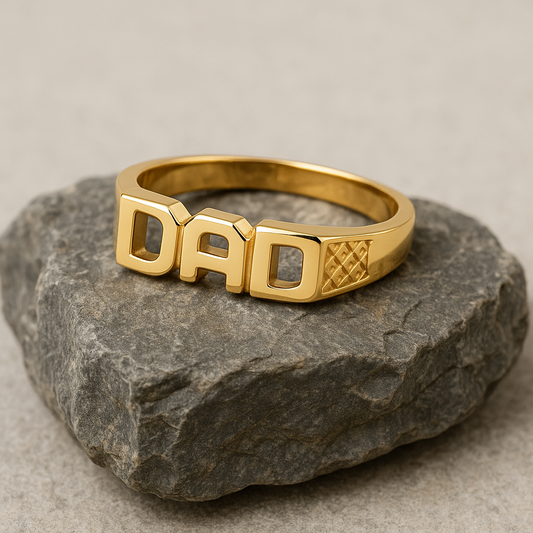 DAD Ring 18ct Yellow Gold On Solid Sterling Silver displayed on a textured stone surface