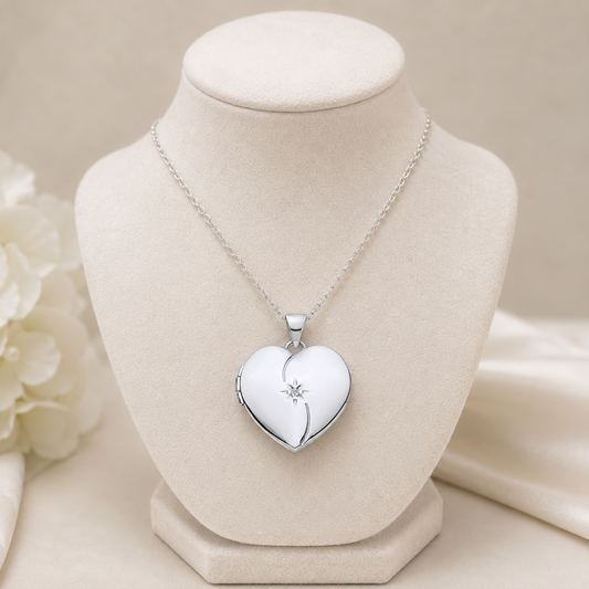 Heart Shaped Silver Locket on a display bust with an elegant chain and floral background