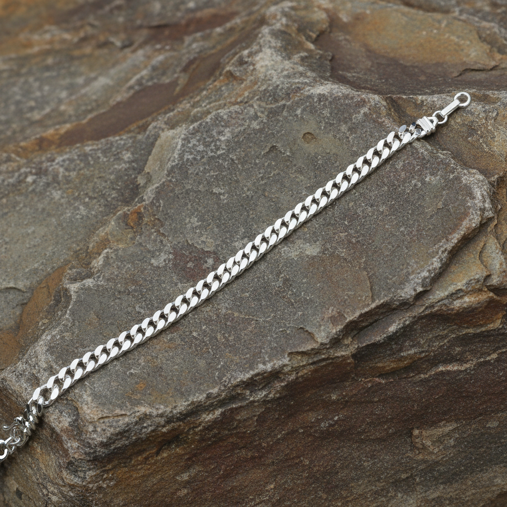 Heavy sterling silver curb bracelet mens with a classic chain design on a natural rock background