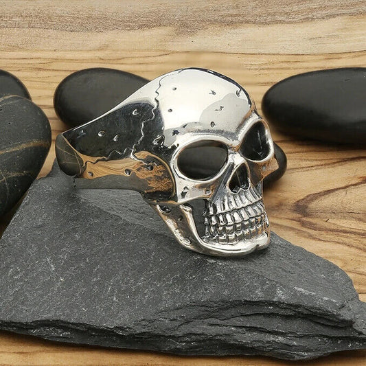 Mens Skull Ring Oxidised Large Grinning Skull Ring with a shiny finish on a wooden surface