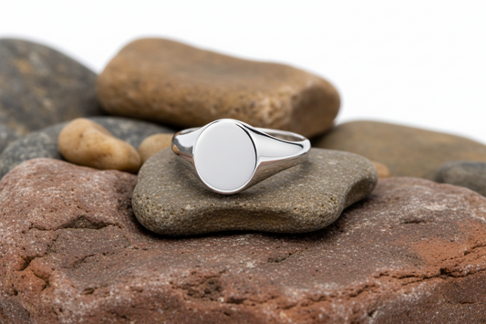 Mens Sterling Silver Oval Signet Ring displayed on smooth stones for a classic look