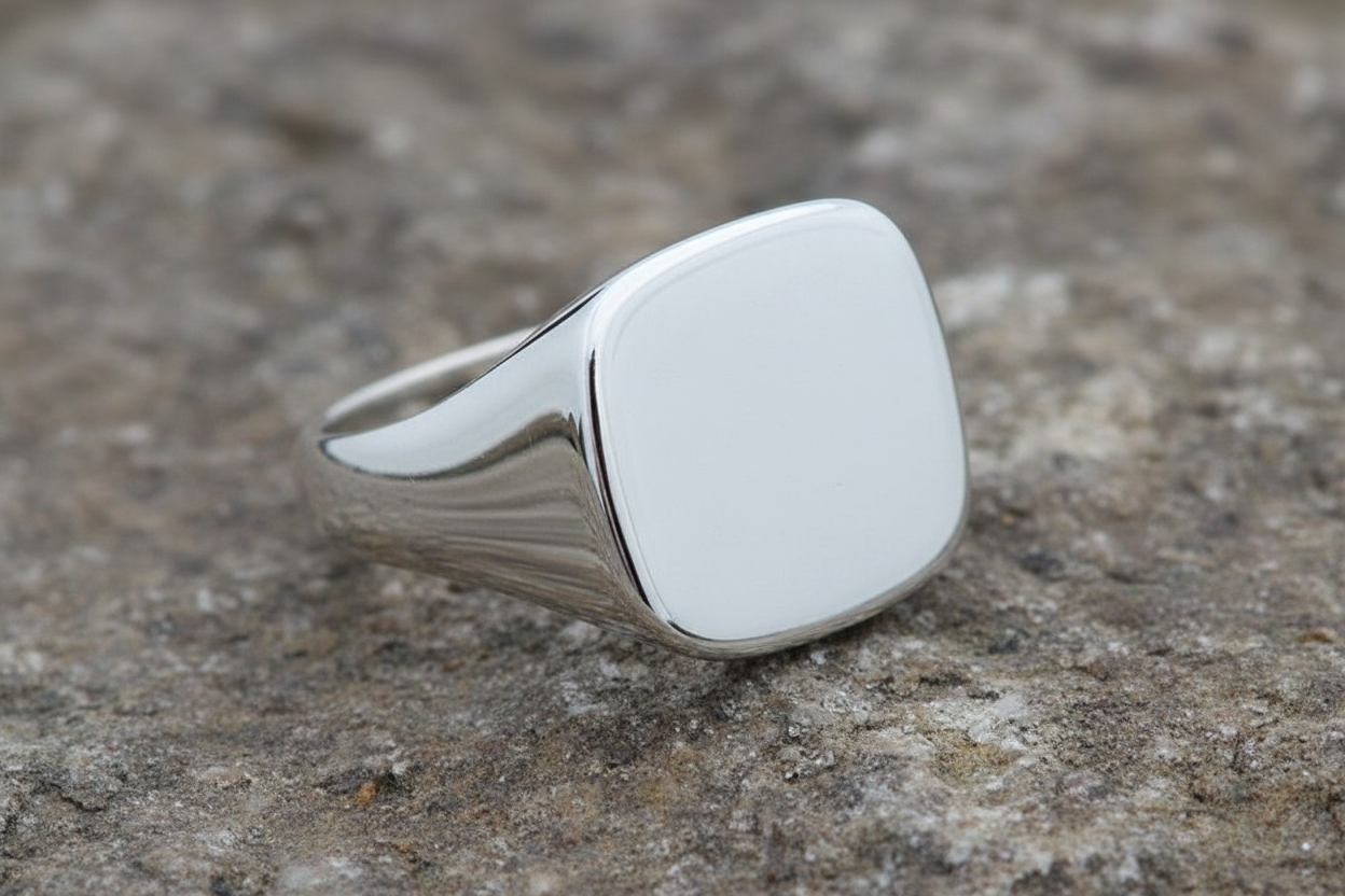 Mens Sterling Silver Square Cushion Signet Ring with a polished finish on a textured surface