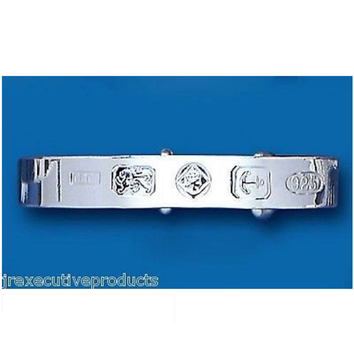 J R Jewellery sterling silver baby bangle with detailed hallmark stamps on blue background