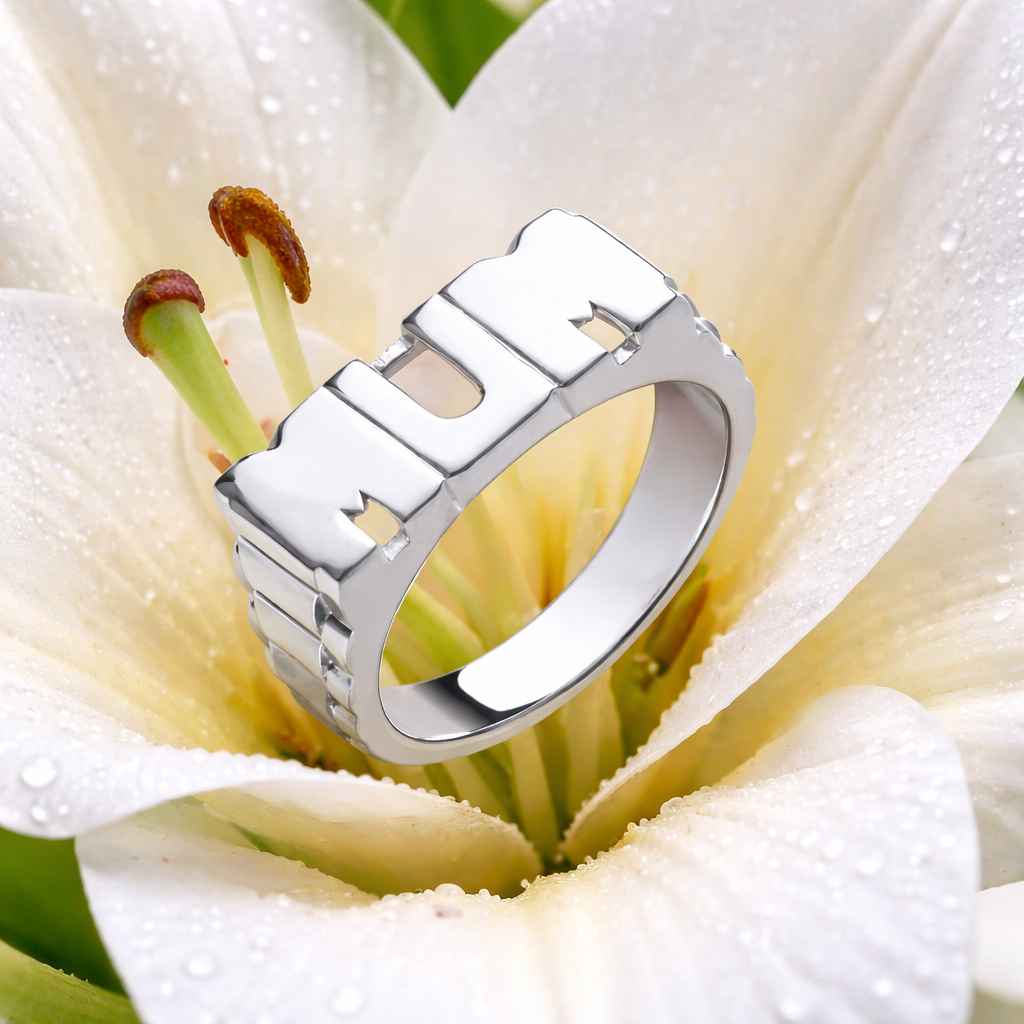 Sterling silver mum ring showcased on a flower, featuring a modern design with clear lettering